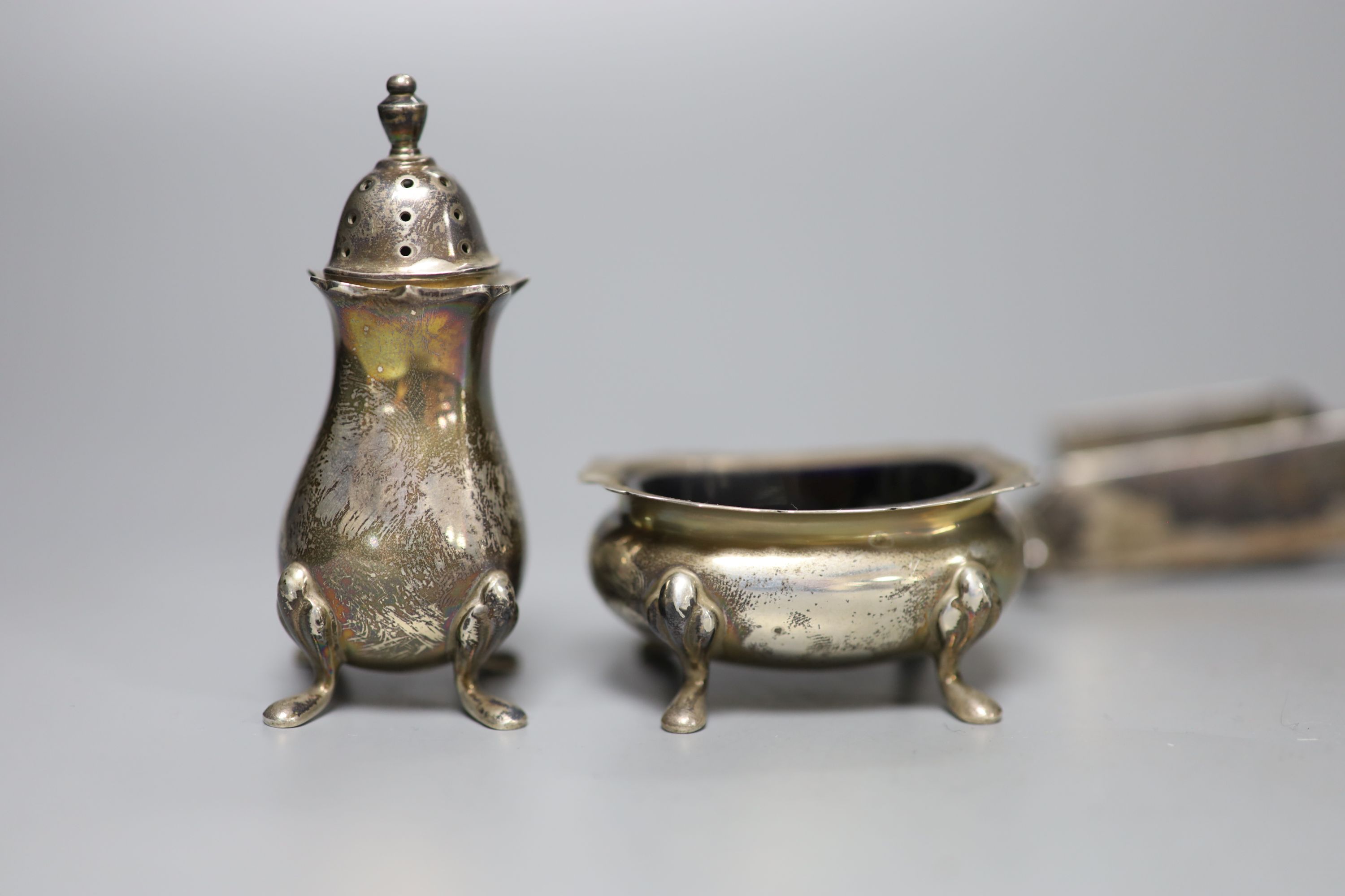 A silver three piece condiment set, a Dutch white metal pill box and a pair of plated candle snuffers.